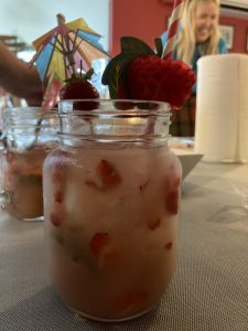A mocktail on a table with some strawberries in.