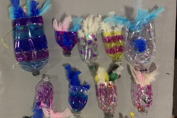 Some plastic bottles decorated with feathers and felt tip pens to make fish.