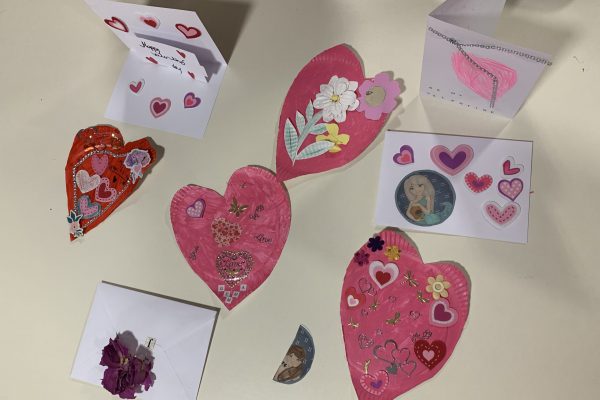 Handmade Valentines cards and hearts on a table.