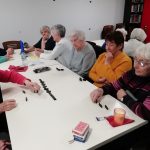 Some of The Devil's Porridge Museum's Cordite Club sat at a table playing dominos and connect four.