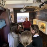 Students stood in the trench section of The Devil's Porridge Museum and with a museum volunteer.