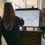 A student using a touchscreen with a map on it at the museum.