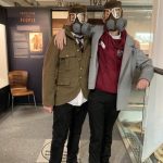 Two students dressing up with replica gas masks.